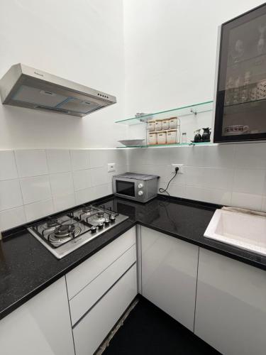 a white kitchen with a stove and a microwave at Fi Makanina in Tunis