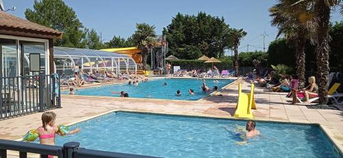 un groupe de personnes dans une piscine d'un complexe hôtelier dans l'établissement Mobil home camping 4 étoile, à Saint-Hilaire-de-Riez