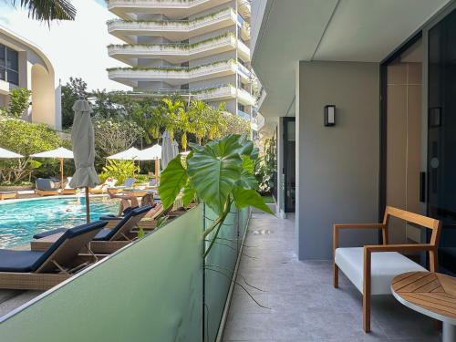 an outdoor patio with chairs and a swimming pool at La Green Hotel and Residence in Bang Tao Beach