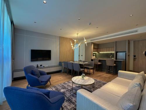 a living room with a couch and a dining room at La Green Hotel and Residence in Bang Tao Beach