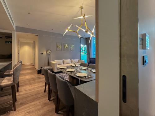 a dining room and living room with a table and chairs at La Green Hotel and Residence in Bang Tao Beach