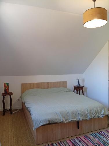 - une chambre avec un lit et deux tables de chevet dans l'établissement ricochets, à Castillon