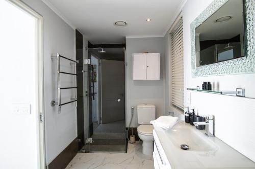a bathroom with a toilet and a sink and a mirror at Cape Town Condo J13 at The Adderley in Cape Town