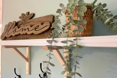 une étagère avec un signe de nom et une plante sur celle-ci dans l'établissement Les Coteaux de Mahé - Tournon-sur-Rhône, à Tournon-sur-Rhône