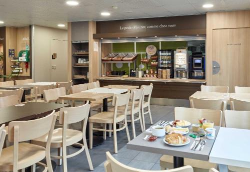 un restaurant avec des tables, des chaises et un comptoir dans l'établissement B&B HOTEL Orly Chevilly Marché International, à Chevilly-Larue