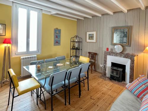 une salle à manger avec une table et des chaises en verre dans l'établissement Villa St Gilles - Quartier ARAGO - 300m Plage, à Les Sables-dʼOlonne