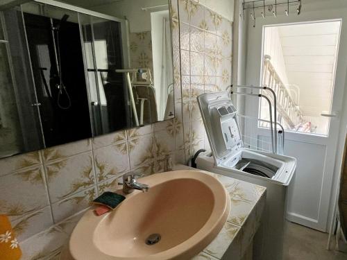 une salle de bain avec un lavabo et un miroir dans l'établissement Villa St Gilles - Quartier ARAGO - 300m Plage, à Les Sables-dʼOlonne