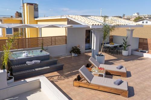 a patio with chairs and a hot tub on a building at Unique apartment in Corfu Town