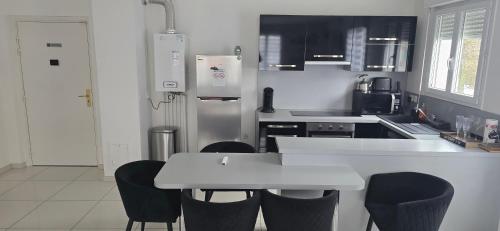 une cuisine avec une table blanche et des chaises dans l'établissement Disneyland smart appartement, à Serris
