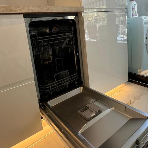 an open drawer in a refrigerator with its door open at Le Soleil Tropézien, Somptueux 2 pièces - Terrasse Vue Mer in Menton