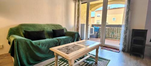 un salon avec un canapé vert et une table dans l'établissement Modern seaside studio, à Fréjus
