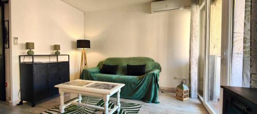 un salon avec une chaise verte et une table dans l'établissement Modern seaside studio, à Fréjus