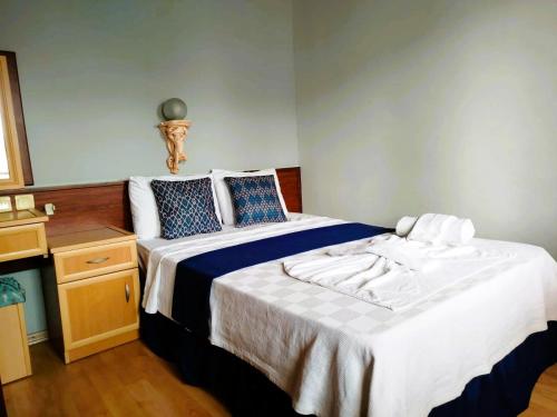a bedroom with a large bed with blue and white sheets at Han Dalyan Hotel in Dalyan