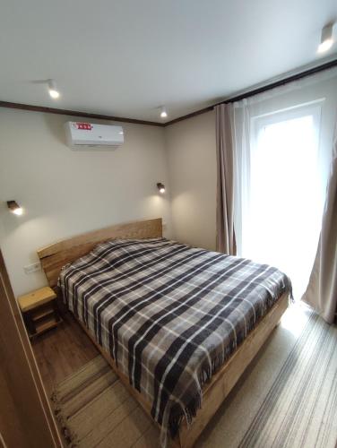 a bedroom with a bed with a plaid blanket at Family Plai in Yaremche