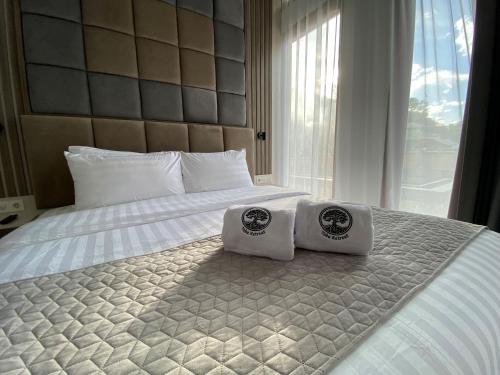 a bedroom with two towels on a bed at Toba Retreat Mansion and Villas in Tomok