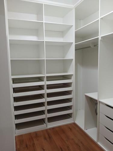 a walk in closet with white shelves at Chalet Rustico da Elena com Sauna y Jacuzzi Unicep in São Carlos