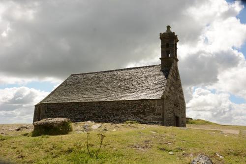 an old stone church on a grassy hill at Gîte de Rosvern in Commana
