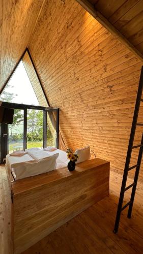 a bedroom with a bed with a window and a ladder at Perryland Urban Farm in Piatra