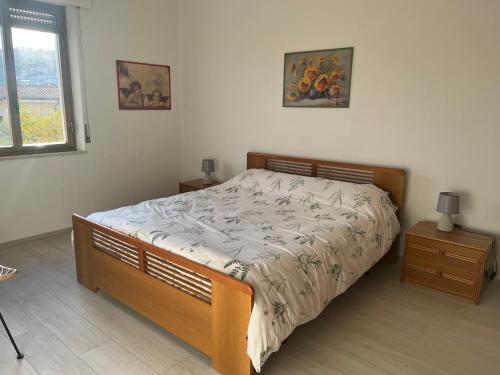 a bedroom with a bed and two tables and a window at Casa Monni vista mare in Santa Maria Navarrese