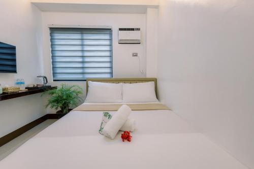 a white bed in a room with a window at Loboc Riverside Inn & Restaurant in Loboc