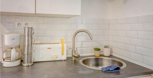 un comptoir de cuisine avec un évier et un mitigeur dans l'établissement T2 dans le centre de Paramé, à Saint-Malo