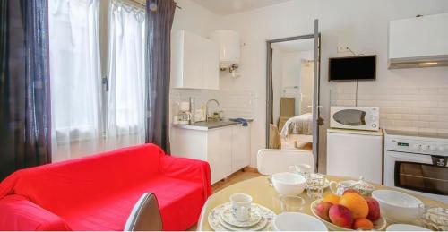 - un salon avec un canapé rouge et une table avec des fruits dans l'établissement T2 dans le centre de Paramé, à Saint-Malo