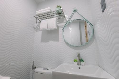 a white bathroom with a mirror and a sink at Loboc Riverside Inn & Restaurant in Loboc