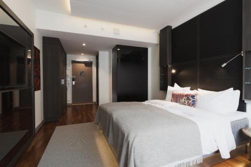 a bedroom with a large bed with a black headboard at Home Hotel Jugend in Helsinki