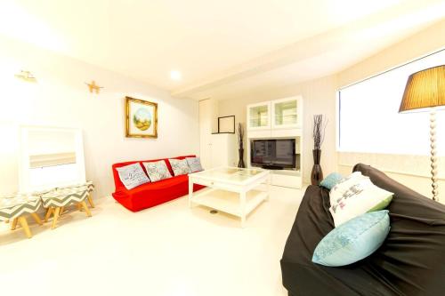 a living room with a couch and a table at Ragsus3F ラグザス3F in Osaka