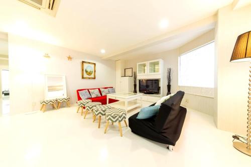 a living room with a red couch and chairs at Ragsus3F ラグザス3F in Osaka