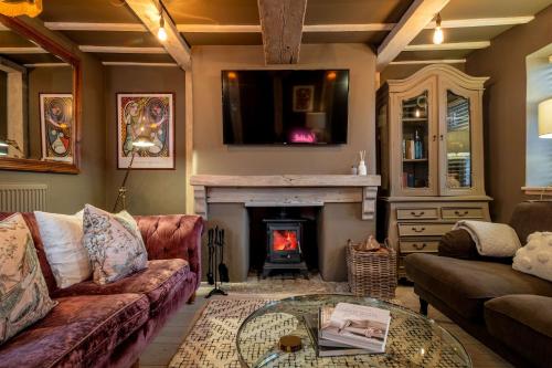 a living room with a couch and a fireplace at Purple Poppy Cottage in Burton Joyce