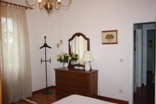 a bedroom with a dresser with a mirror and a lamp at Tenuta Poggio alla Farnia in Fauglia