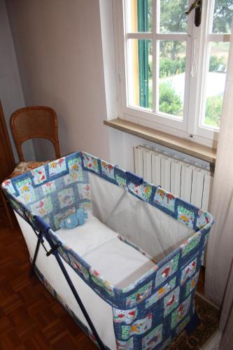 a baby crib in a room with a window at Tenuta Poggio alla Farnia in Fauglia