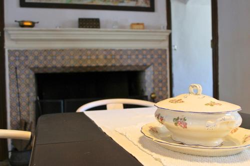 a tea pot sitting on a table in front of a fireplace at La Casa Noble in Jabugo