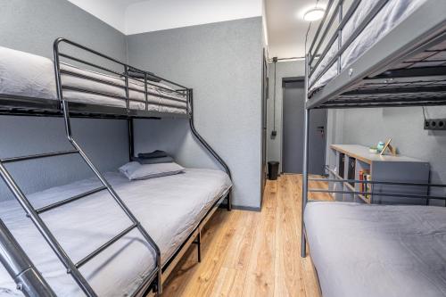 two bunk beds in a room with wooden floors at Hotel Tērbata in Valmiera