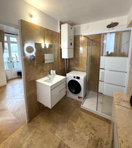 une salle de bain avec un lavabo et une machine à laver dans l'établissement Studio neuf climatisé - Triangle d'Or, à Vichy
