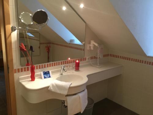 ein Badezimmer mit Waschbecken und Spiegel in der Unterkunft LOGIS DES CHEVALIERS & ROCK SPA WELLNESS Esch sur Sure in Esch-sur-Sûre