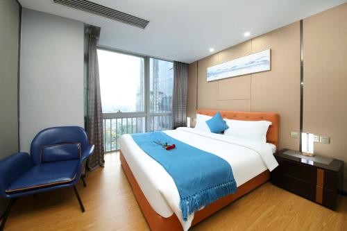 a bedroom with a large bed and a blue chair at Pengman Beijing Road A-mall Apartment - Free Shuttle to Canton Fair in Guangzhou