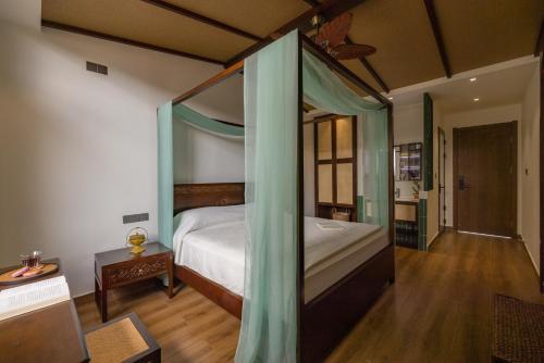 a bedroom with a bed with a canopy at 22 Garden House in Jinghong
