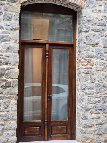 a wooden door in a stone building with a window at Αρχοντικό Ορεάδες ΙΙΙ in Nafpaktos