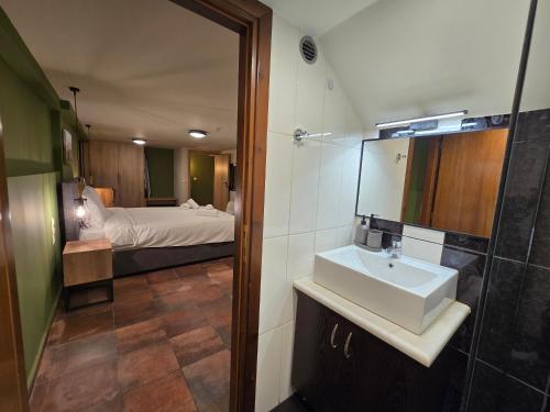 a bathroom with a sink and a bedroom with a bed at Αρχοντικό Ορεάδες ΙΙΙ in Nafpaktos
