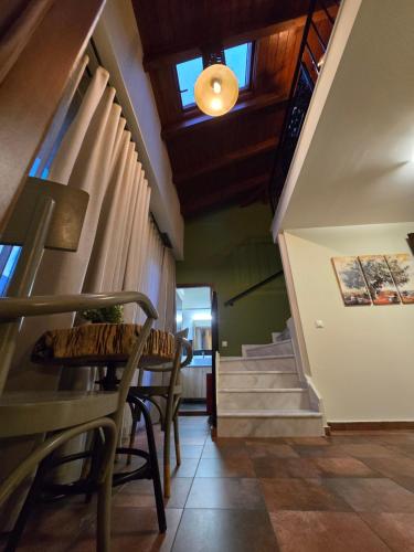 a hallway with a table and chairs and stairs at Αρχοντικό Ορεάδες ΙΙΙ in Nafpaktos