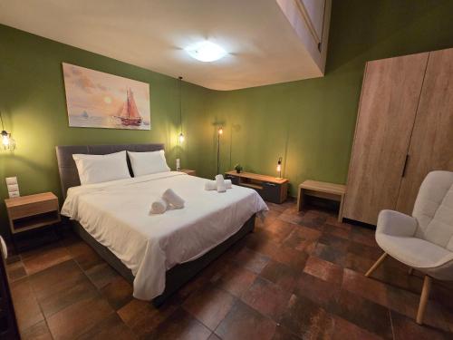 a bedroom with a large white bed and a chair at Αρχοντικό Ορεάδες ΙΙΙ in Nafpaktos