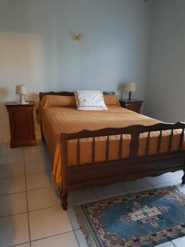 une chambre avec un lit avec deux tables de nuit et deux lampes dans l'établissement Maison de campagne Cap Corse, à Luri