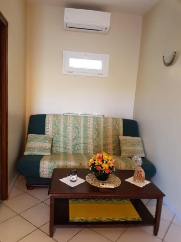 un salon avec un canapé et une table avec des fleurs dans l'établissement Maison de campagne Cap Corse, à Luri