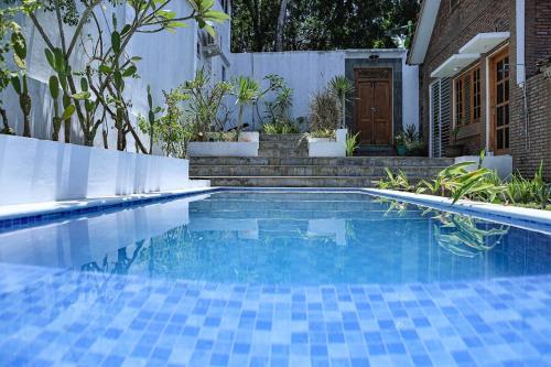una piscina con azulejos azules en un patio en Casarita Villa Jogja, en Jarakan