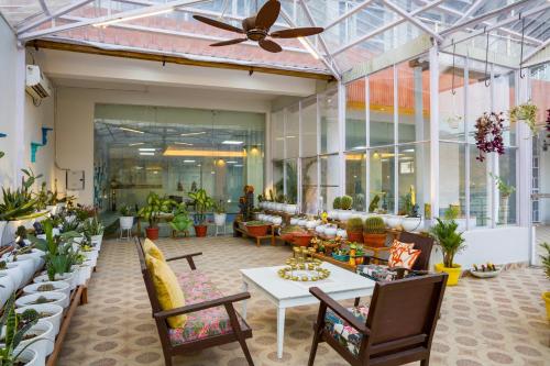 un salón acristalado con mesa, sillas y plantas en ELIVAAS BYDM The Ganges 2 BHK Glasshouse Villa With Pvt Pool & Lift, en Rishīkesh