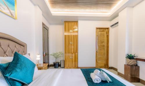 a bedroom with a bed with blue pillows at Loboc Riverside Inn & Restaurant in Loboc