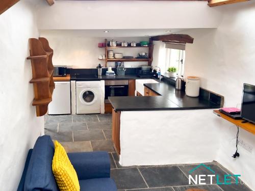 a kitchen with a washer and dryer at Ty Bedwen - Cosy Rural Retreat in St Davids in St. Davids