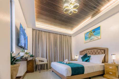 a bedroom with a bed and a desk and a tv at Loboc Riverside Inn & Restaurant in Loboc